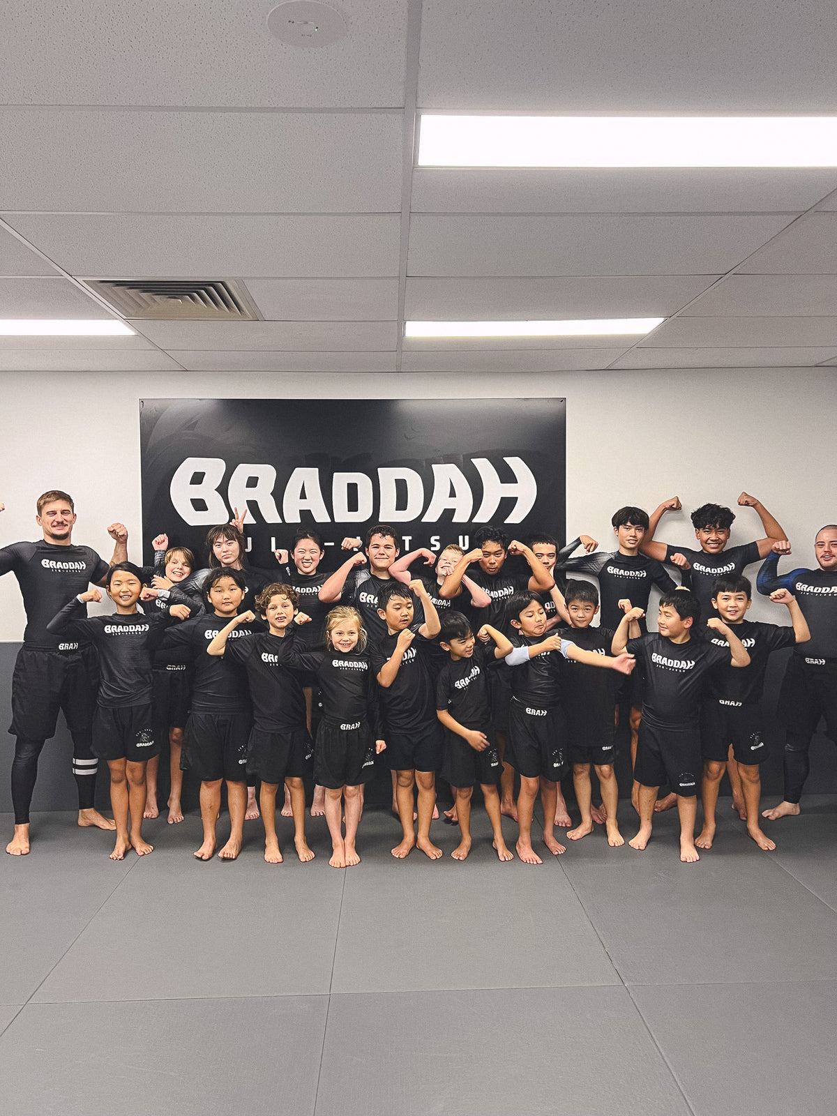 Braddah Jiu-Jitsu Artarmon coaches and children posing together in the academy