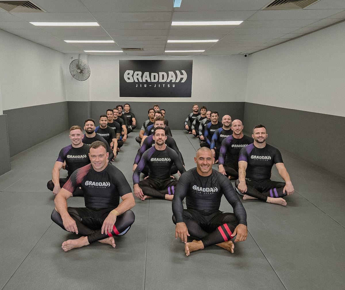 Adults training Brazilian Jiu-Jitsu in No-Gi uniforms during class